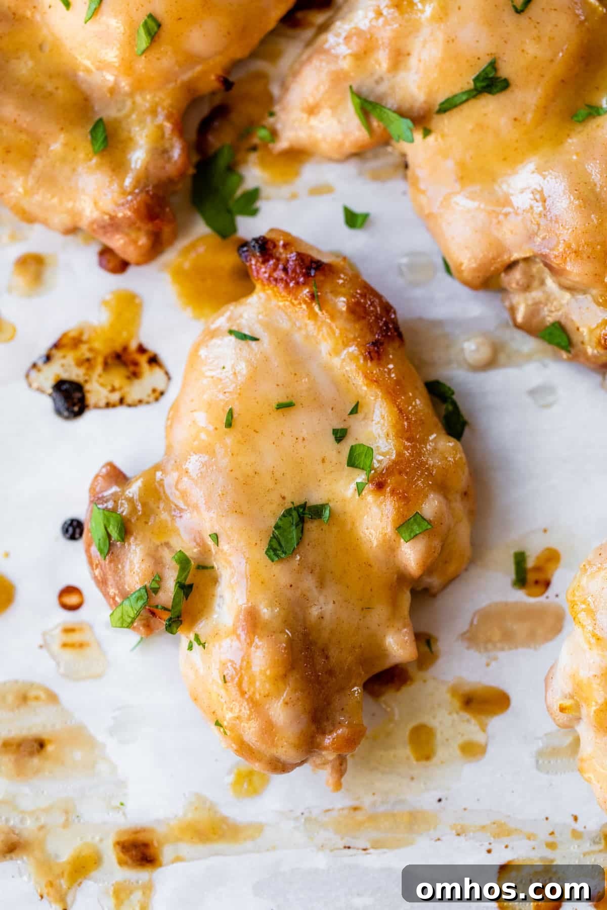 marinated chicken thighs topped with parsley on parchment paper