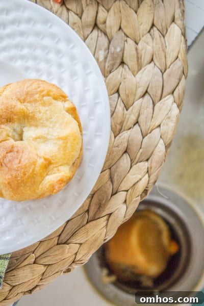 Mini chicken pot pie fallen into sink drain with a mini chicken pot pie on a white plate above it.