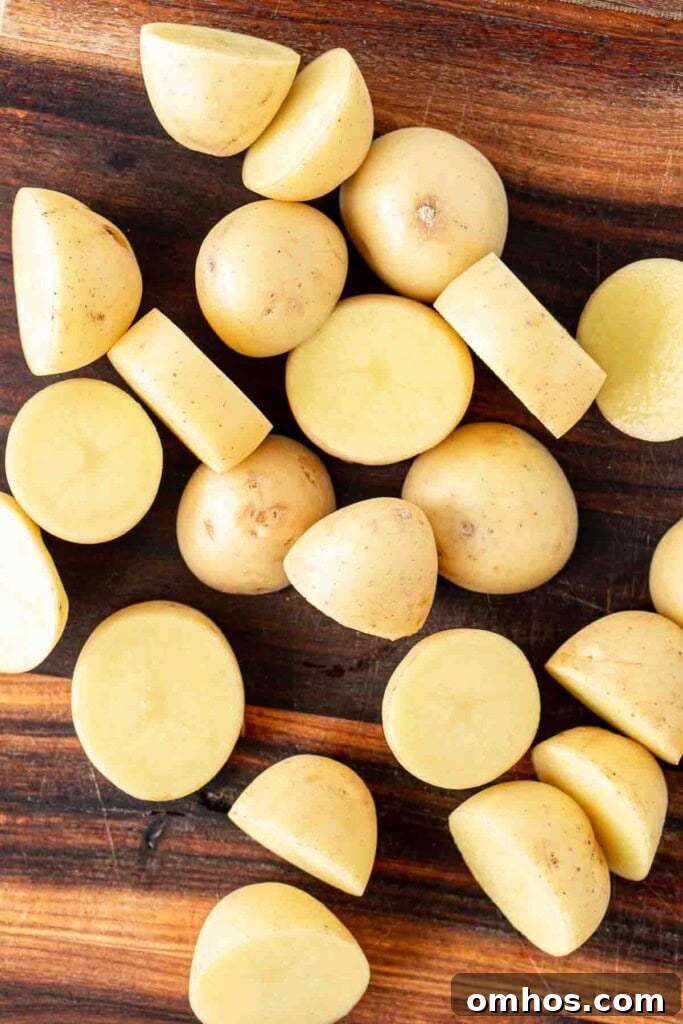 Crispy Air Fryer Potatoes with Garlic and Herbs 4 Cut baby potatoes on a chopping board.