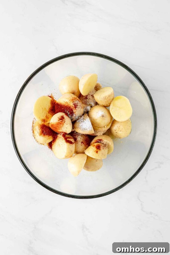 Crispy Air Fryer Potatoes with Garlic and Herbs 5 Cut potatoes in a mixing bowl with seasoning.