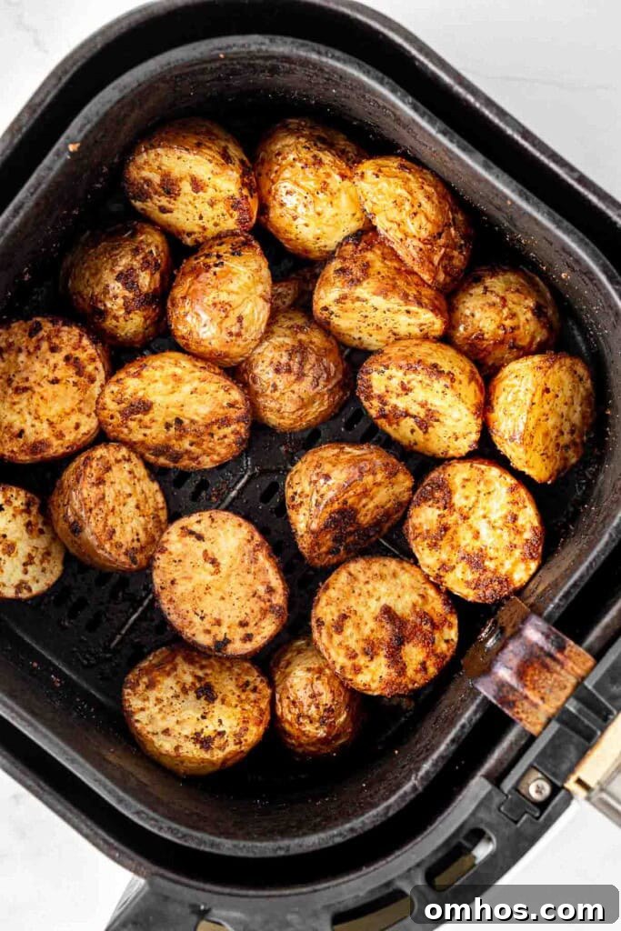 Crispy Air Fryer Potatoes with Garlic and Herbs 7 Close up of roasted potatoes in the air fryer basket.