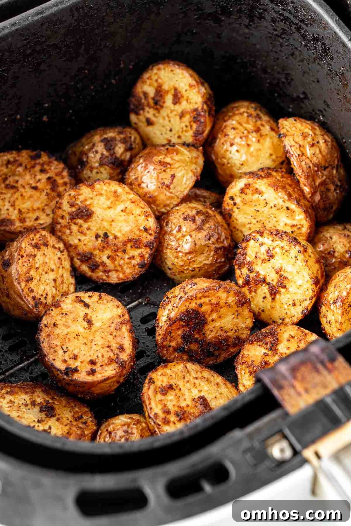 Crispy Air Fryer Potatoes with Garlic and Herbs 8 Close up of roasted potatoes in the air fryer basket.