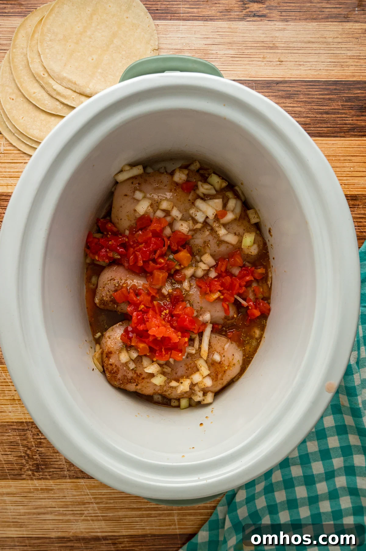 Classic King Ranch Chicken Casserole Recipe 3 Chicken breasts, seasonings, rotel, broth, and onions in a crockpot.