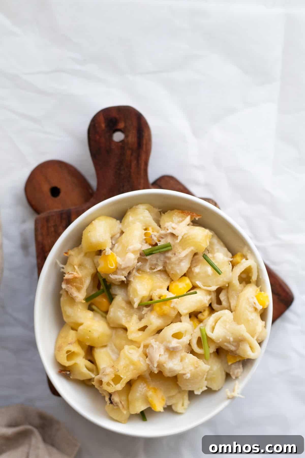 Creamy 30 Minute Tuna and Sweetcorn Pasta Bake Recipe 9 a bowl of tuna sweetcorn pasta on a wooden hot pad