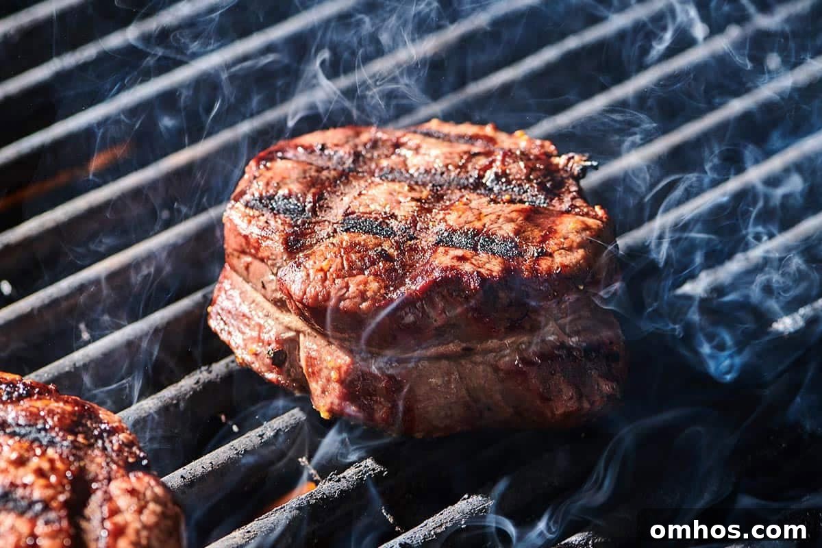 How to Achieve Perfect Crosshatch Grill Marks on Steak 2 Cooked filet mignon steaks with cross-hatch grill marks on cutting board.