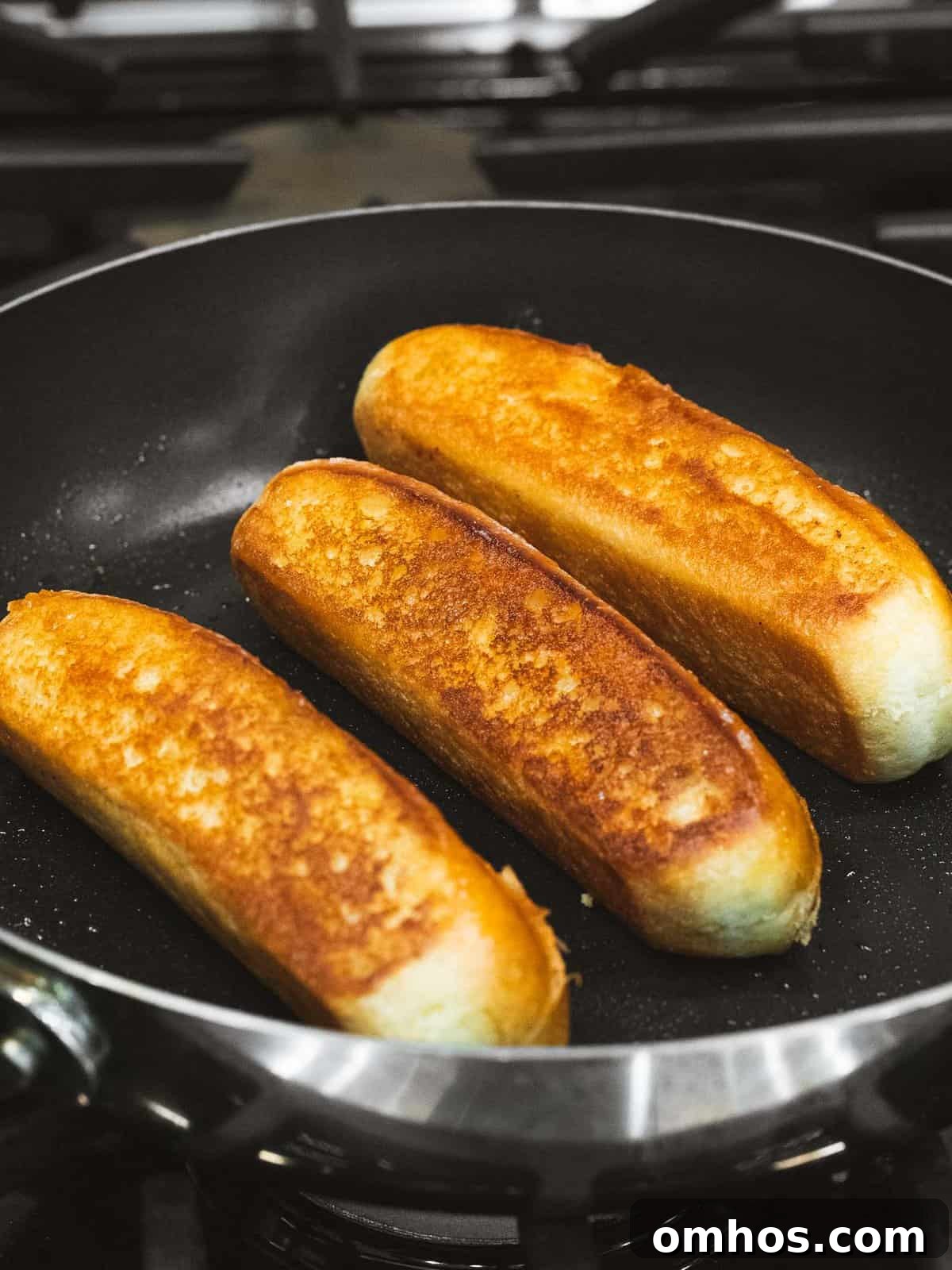 Warm Connecticut-Style Lobster Roll Recipe 5 Lobster roll bun toasting with melted butter in a pan.