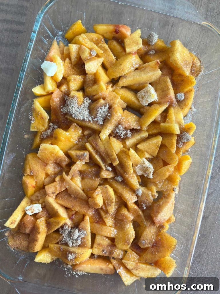 Homemade Fresh Peach Crisp Recipe with Oat Crumble 5 sliced fresh peaches in baking dish with butter and sugar