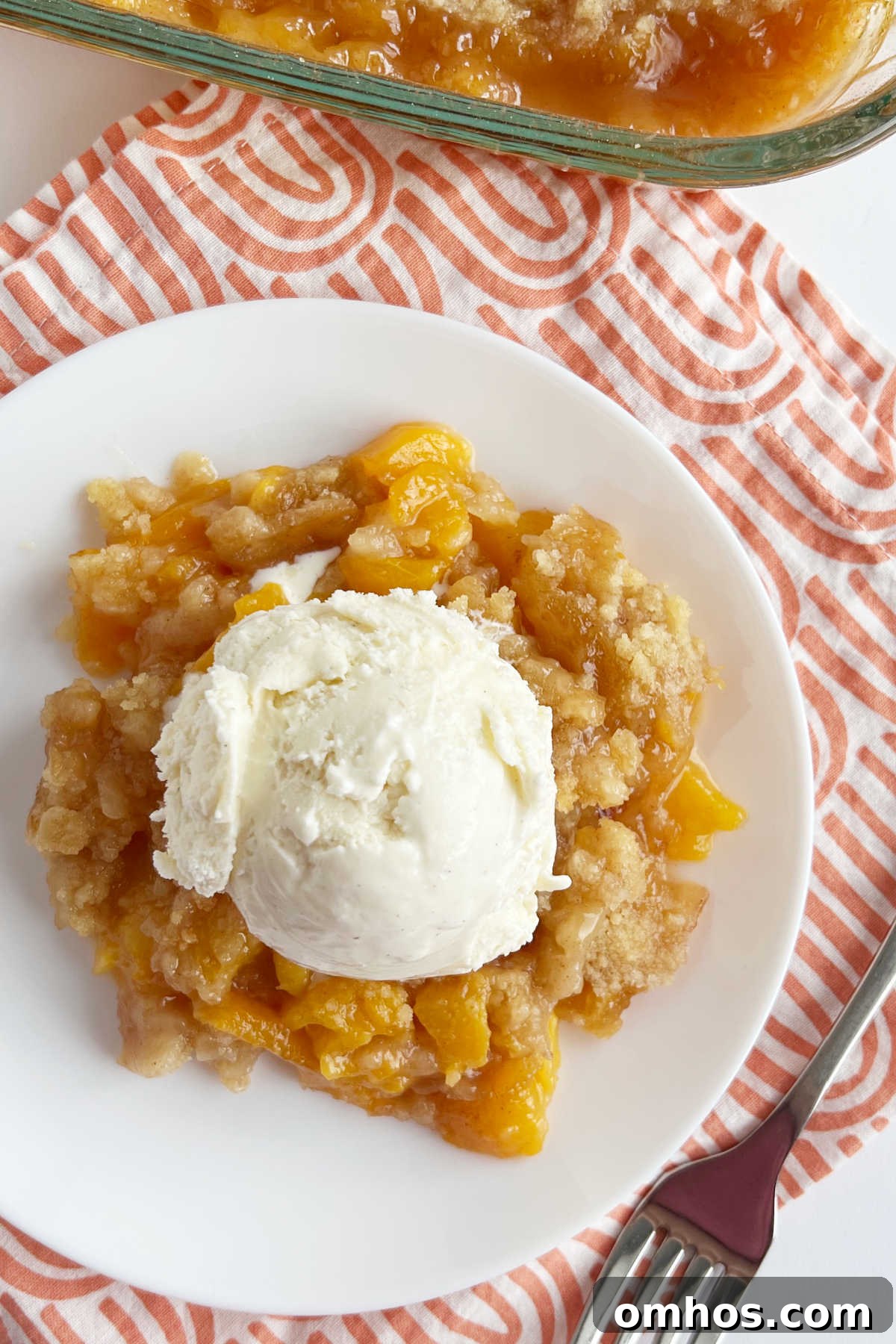Homemade Fresh Peach Crisp Recipe with Oat Crumble 7 serving of peach crisp without oats topped with scoop of ice cream on plate