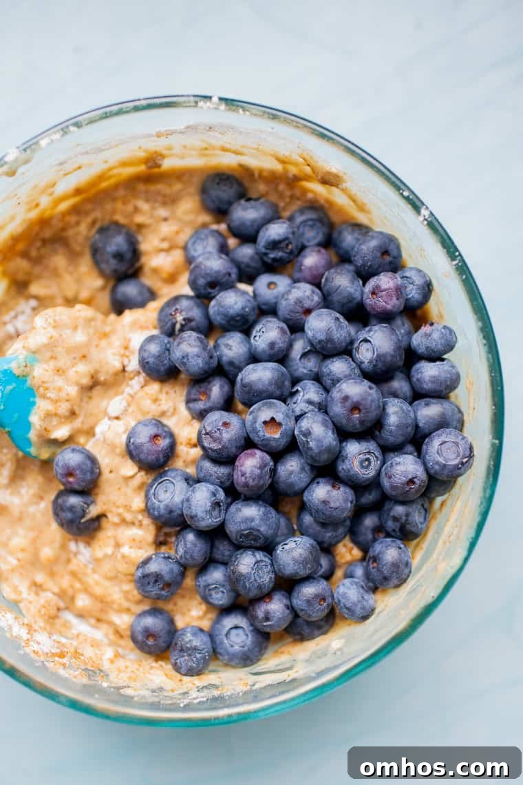 Moist Blueberry Oatmeal Muffins Recipe 2 Glass bowl with muffin batter and blueberries on top.