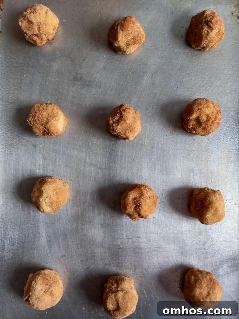 Cookie balls on a large baking tray ready to bake.