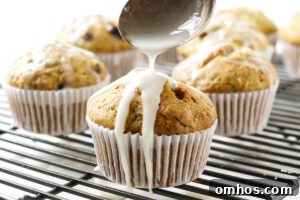 Drizzling a vanilla glaze on top of homemade zucchini muffins.