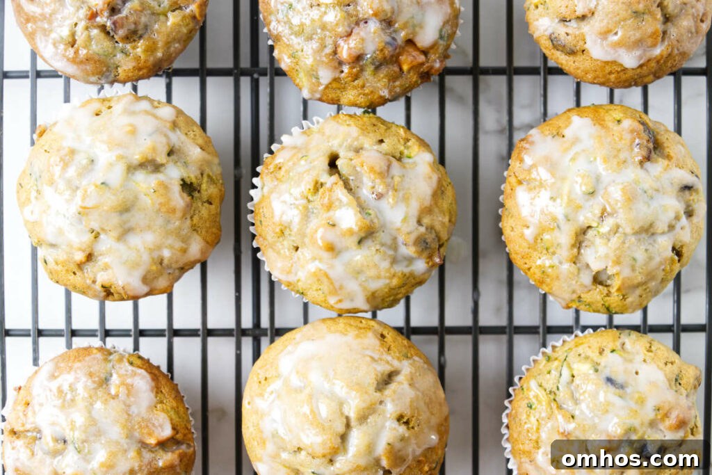 Several muffins on a cooling rack topped with a sweet vanilla glaze.