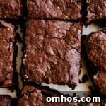 Freshly cut chocolate brownies on white parchment paper.