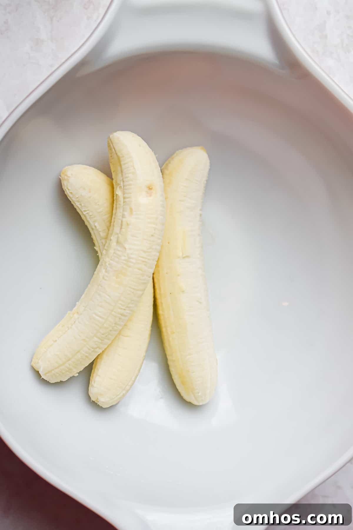 three bananas are in a large mixing bowl