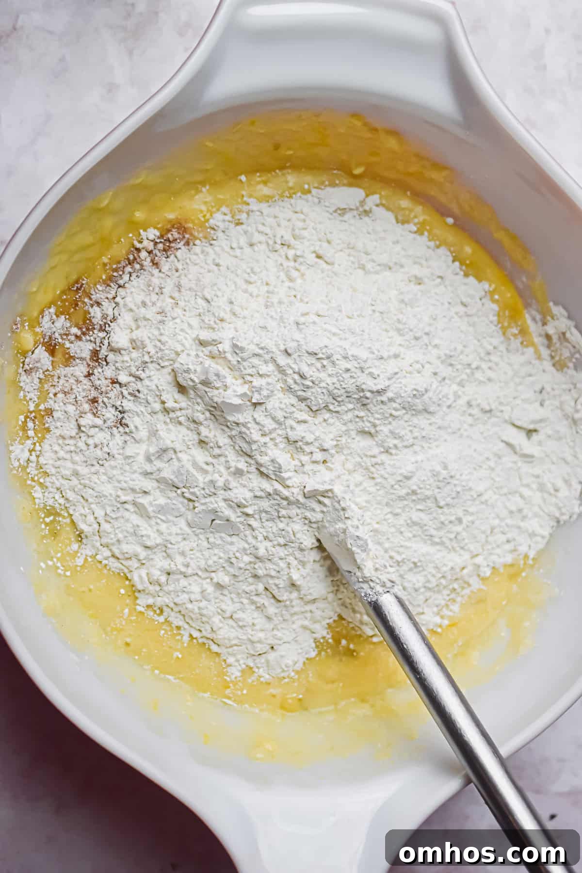 The dry ingredients are added to the bowl with the wet ingredients for the banana muffins with self-rising flour