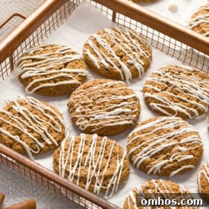 A copper wire tray with gluten-free iced molasses cookies on a parchment paper.