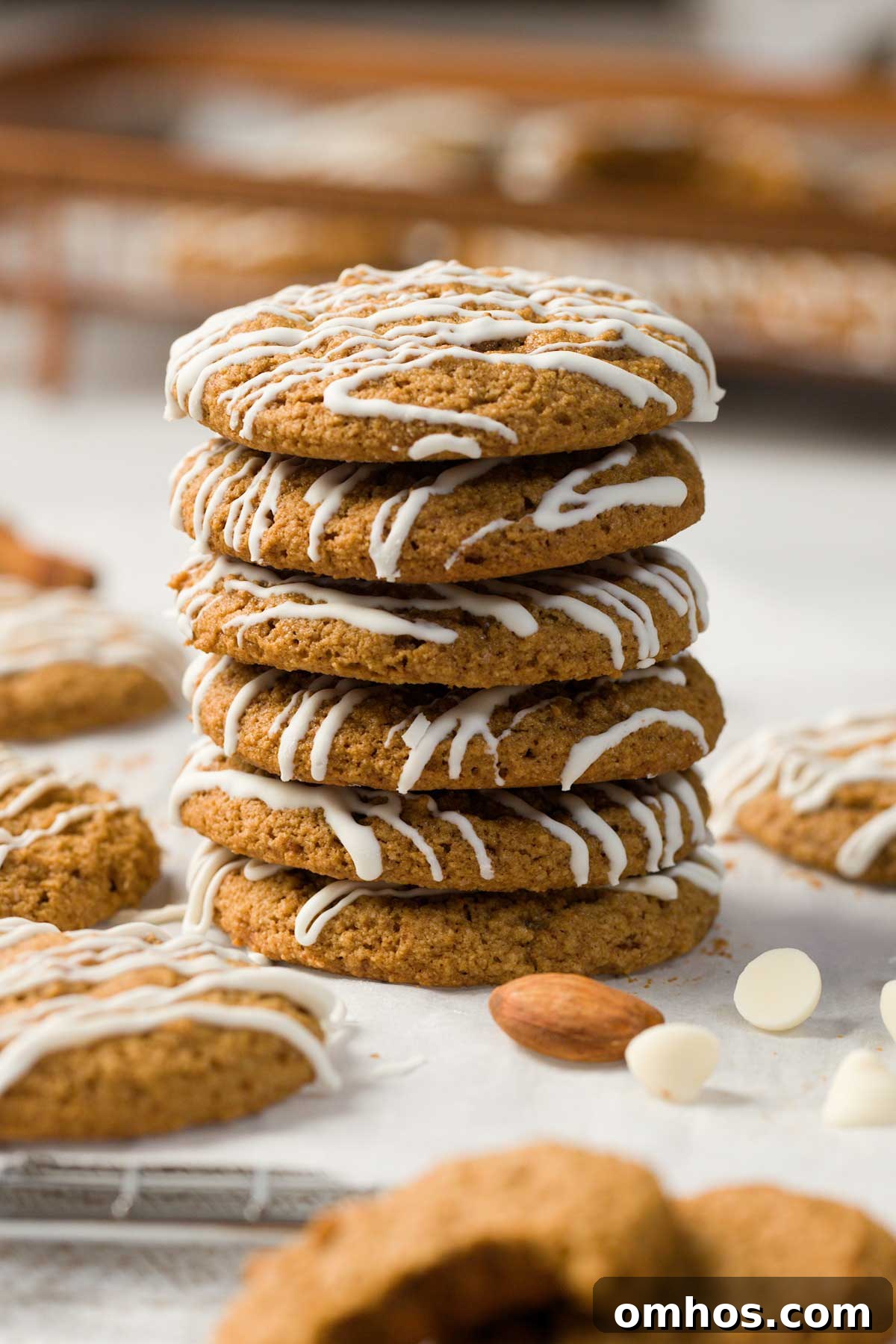 Gluten-Free Iced Ginger Molasses Cookies Recipe 2 Gluten-free iced ginger molasses cookies stacked on a parchment paper.