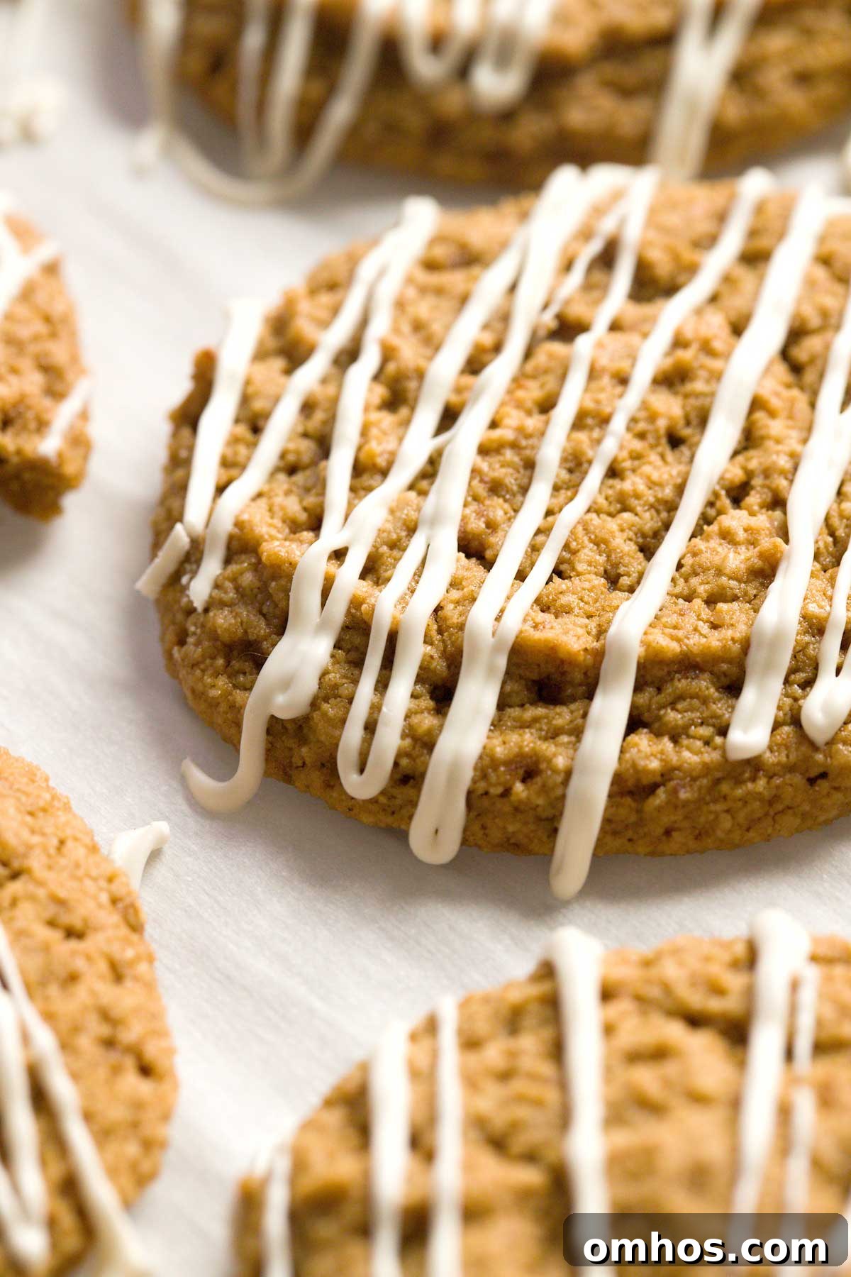 Gluten-Free Iced Ginger Molasses Cookies Recipe 3 Close-up of gluten-free iced ginger molasses cookies on a parchment paper.
