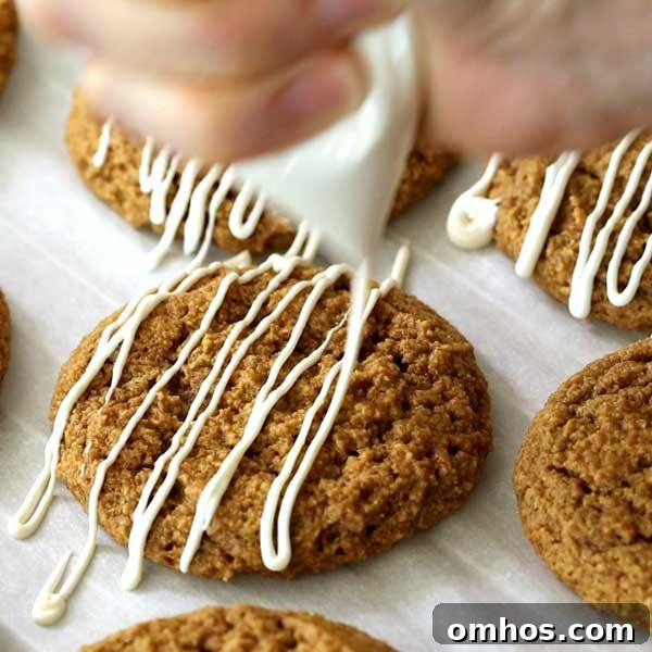 Gluten-Free Iced Ginger Molasses Cookies Recipe 7 Piping icing on gluten-free ginger molasses cookies on a parchment paper.