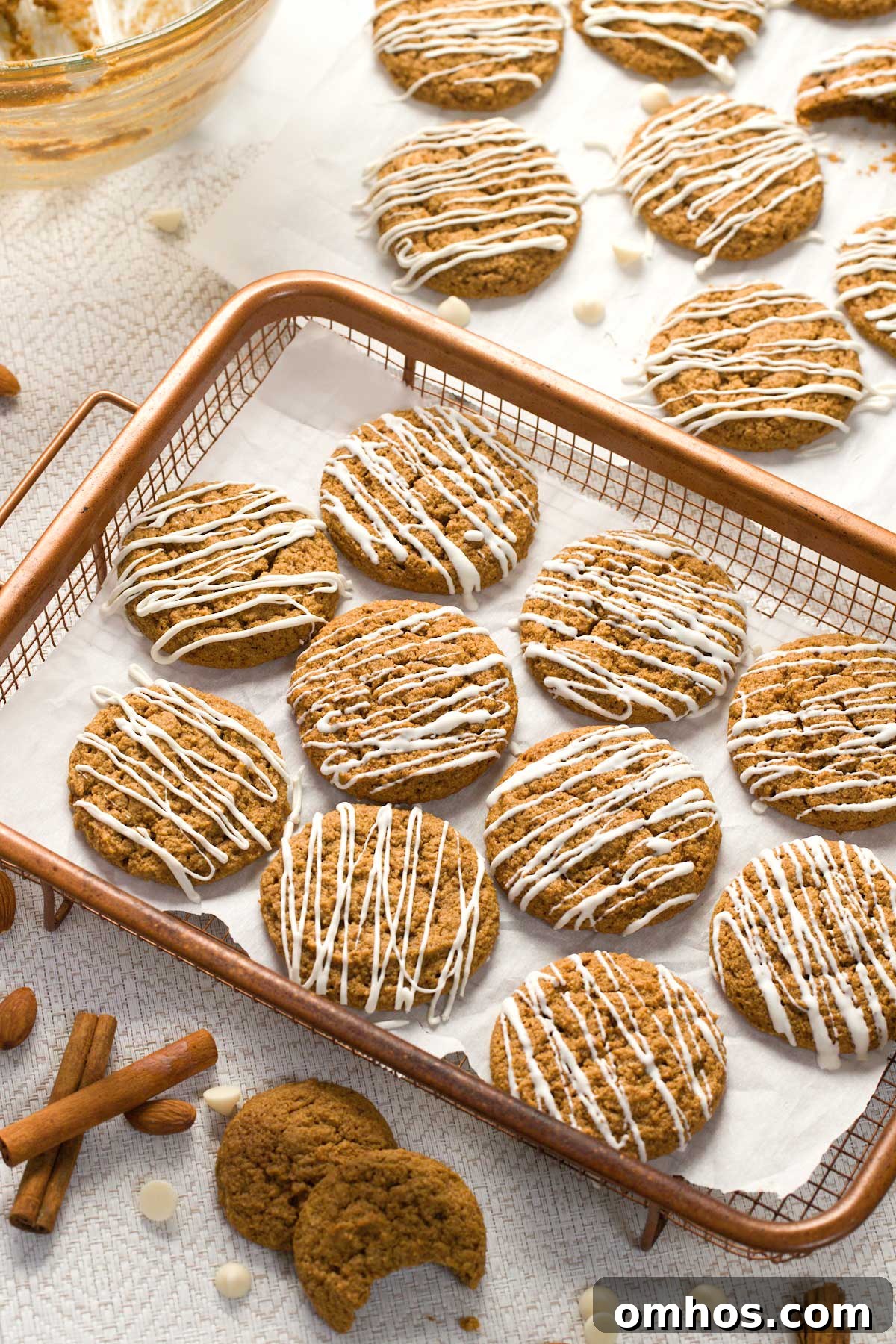 Gluten-Free Iced Ginger Molasses Cookies Recipe 8 Gluten-free iced ginger molasses cookies on parchment paper in a copper basket.