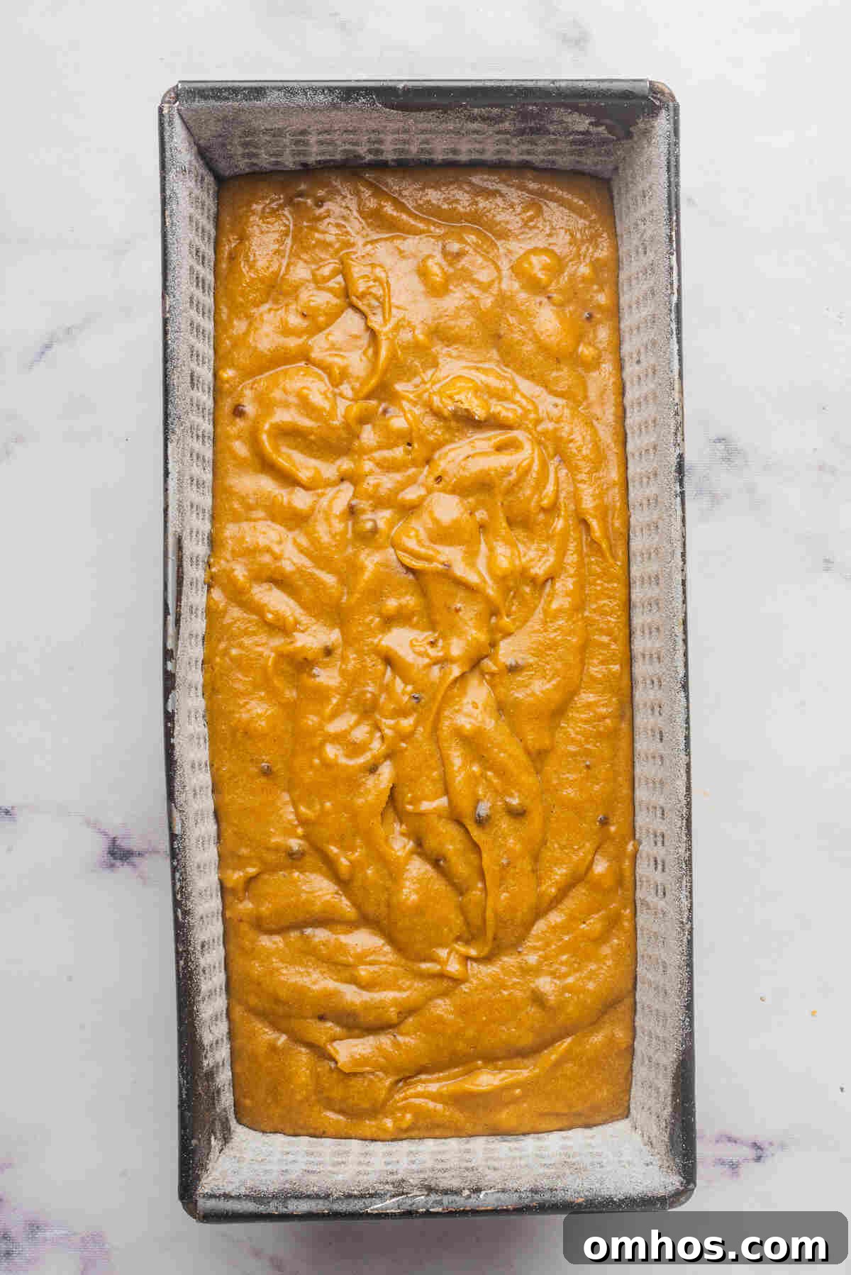 Starbucks-Style Pumpkin Bread Recipe 8 A loaf pan filled with bread batter, ready to be baked.