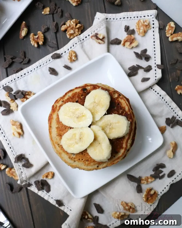 Overhead view of sliced bananas on top of a stack of Oatmeal Chocolate Chip Banana Pancakes