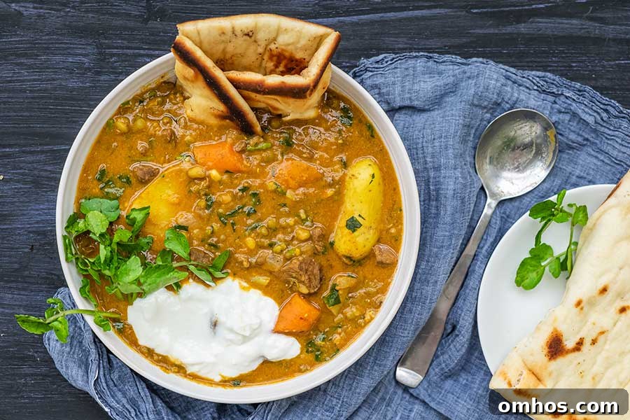 bowl of spiced beef stew with mung beans cooked in instant pot with naan and sour cream