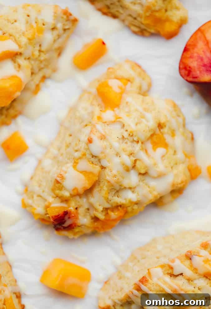 close up on a baked peach scone with a white glaze on top