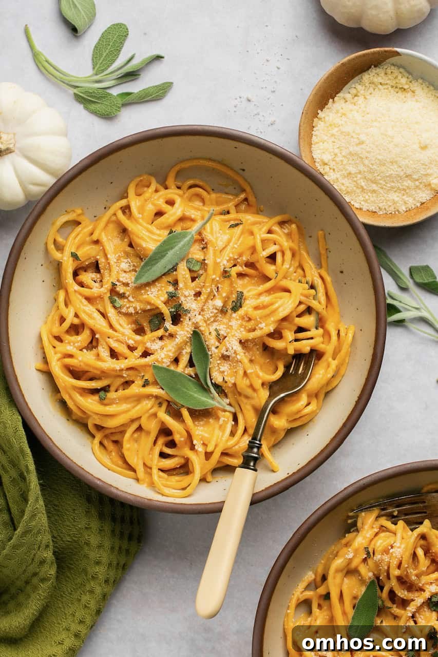 Creamy Pumpkin Pasta Sauce Recipe 2 pumpkin pasta in 2 bowls topped with parmesan and sage with a fork in the bowl
