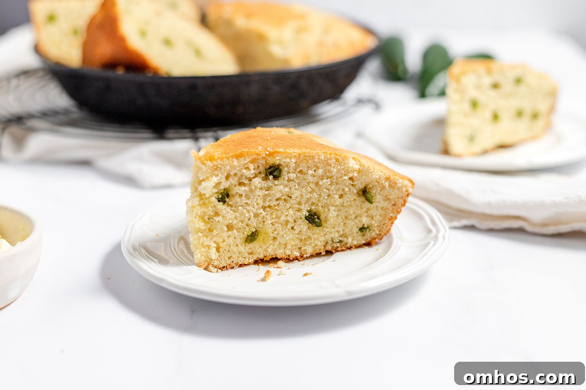A slice of jalapeno cornbread on a white plate.
