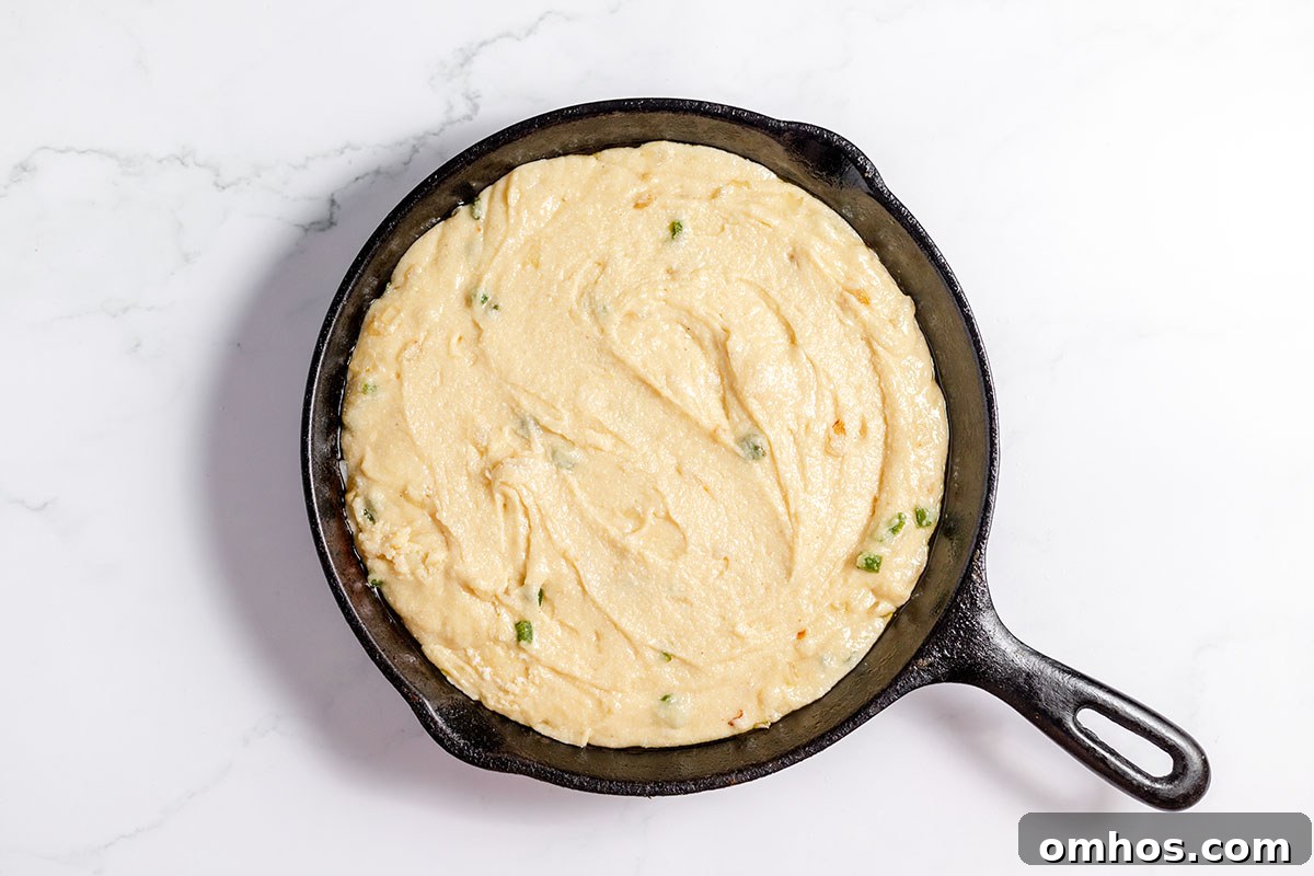 Jalapeno cornbread batter poured into a cast iron skillet.