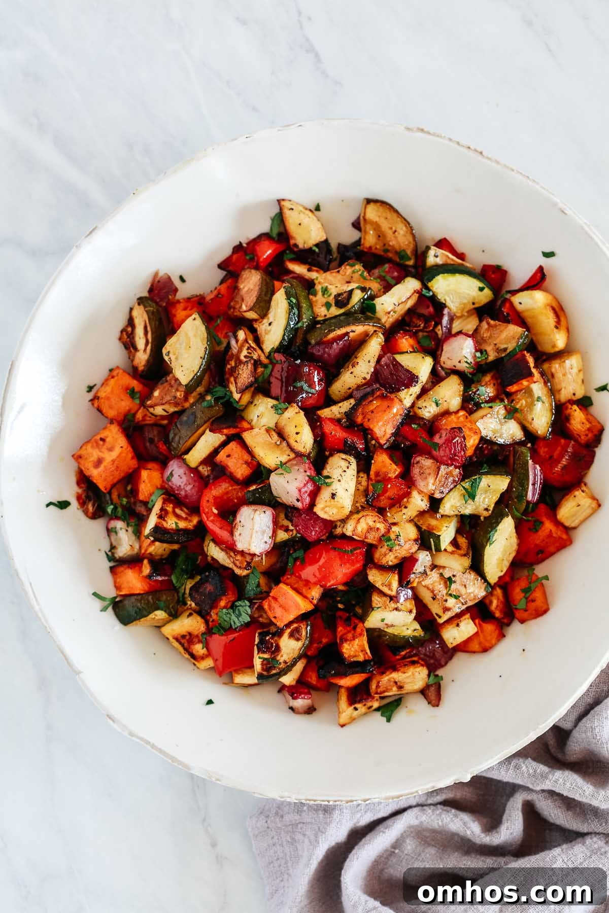 An overhead photo of a white bowl with balsamic roasted veggies inside.