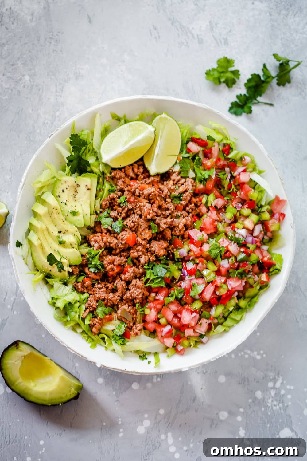 An overhead photo of a white plate of ground beef taco salad 