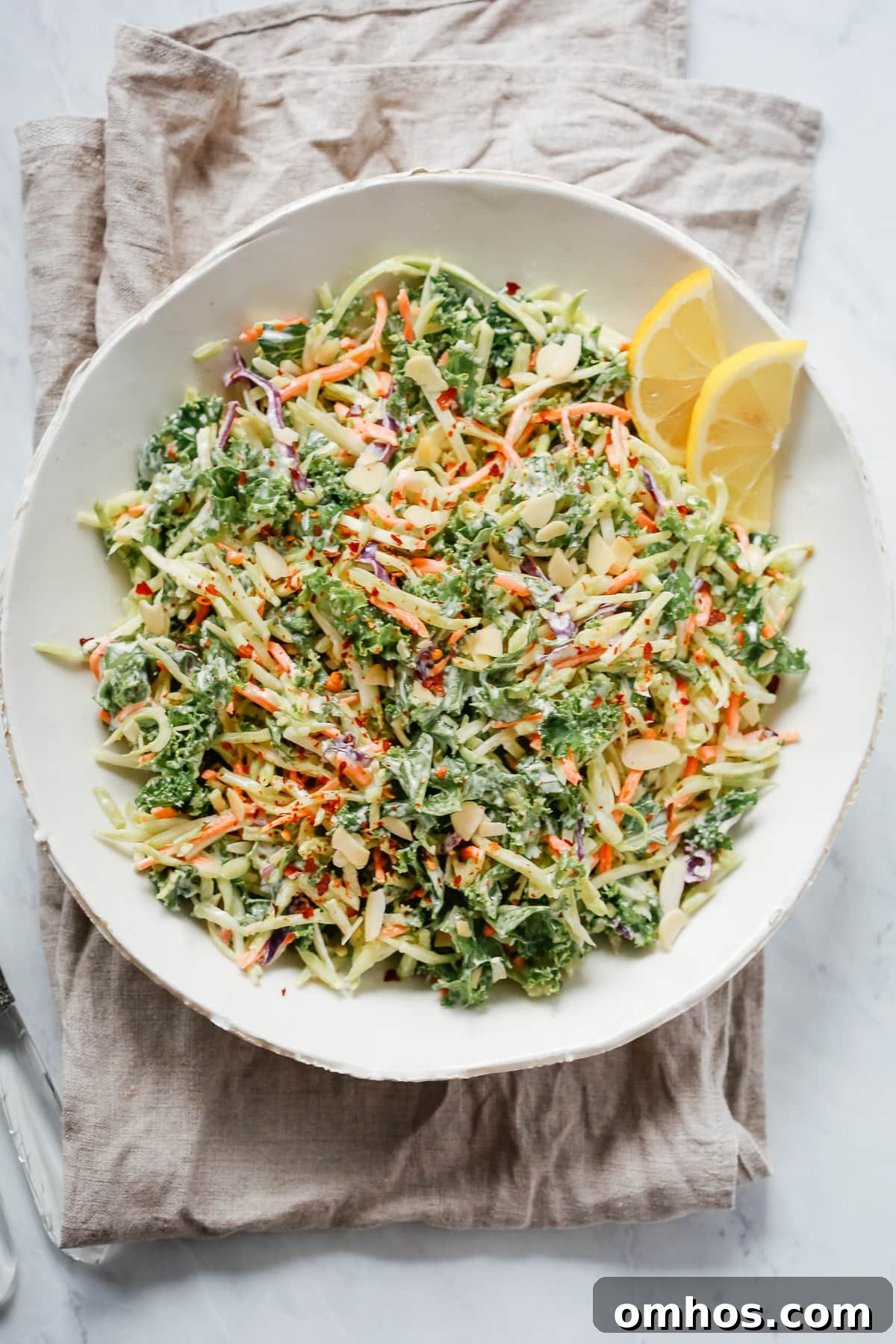 overhead view of a white bowl of broccoli kale slaw salad 