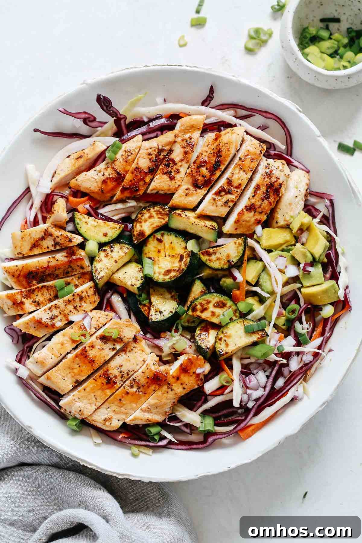 Overhead shot of cabbage salad with grilled chicken.