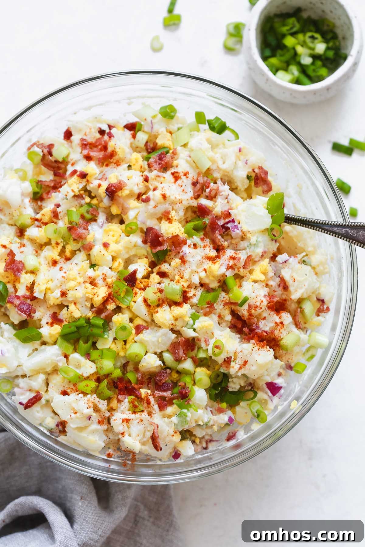 Overhead photo of a potato salad in a glass bowl.