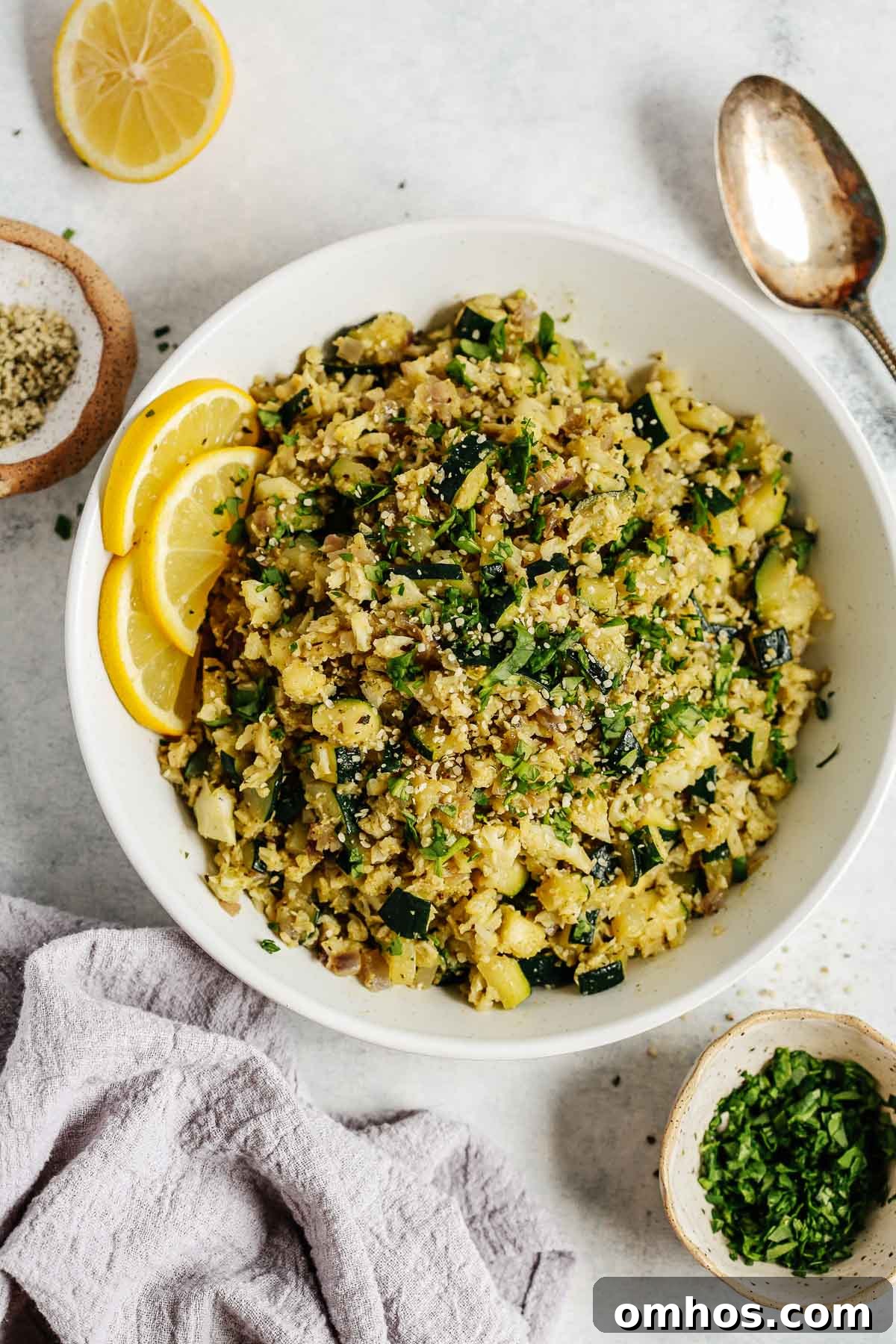 Overhead photo of a white bowl with zucchini cauliflower rice.