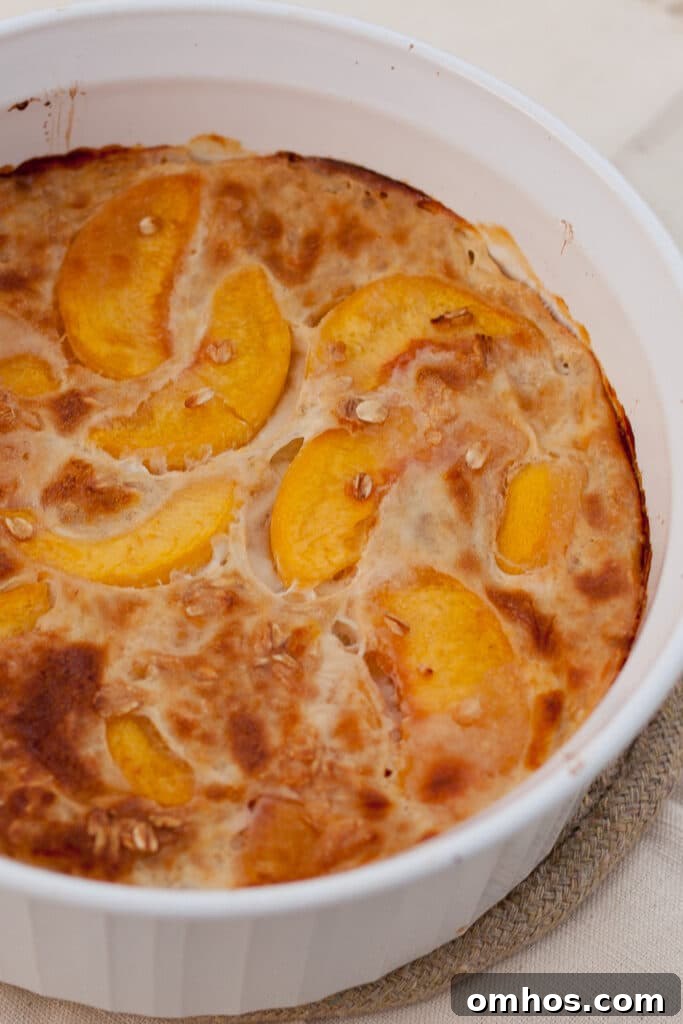 a large casserole dish filled with baked oatmeal with peaches in it.
