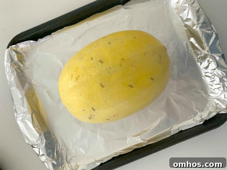 How to Cook Whole Spaghetti Squash in Slow Cooker or Oven 4 Spaghetti squash on baking sheet lined with aluminum foil.