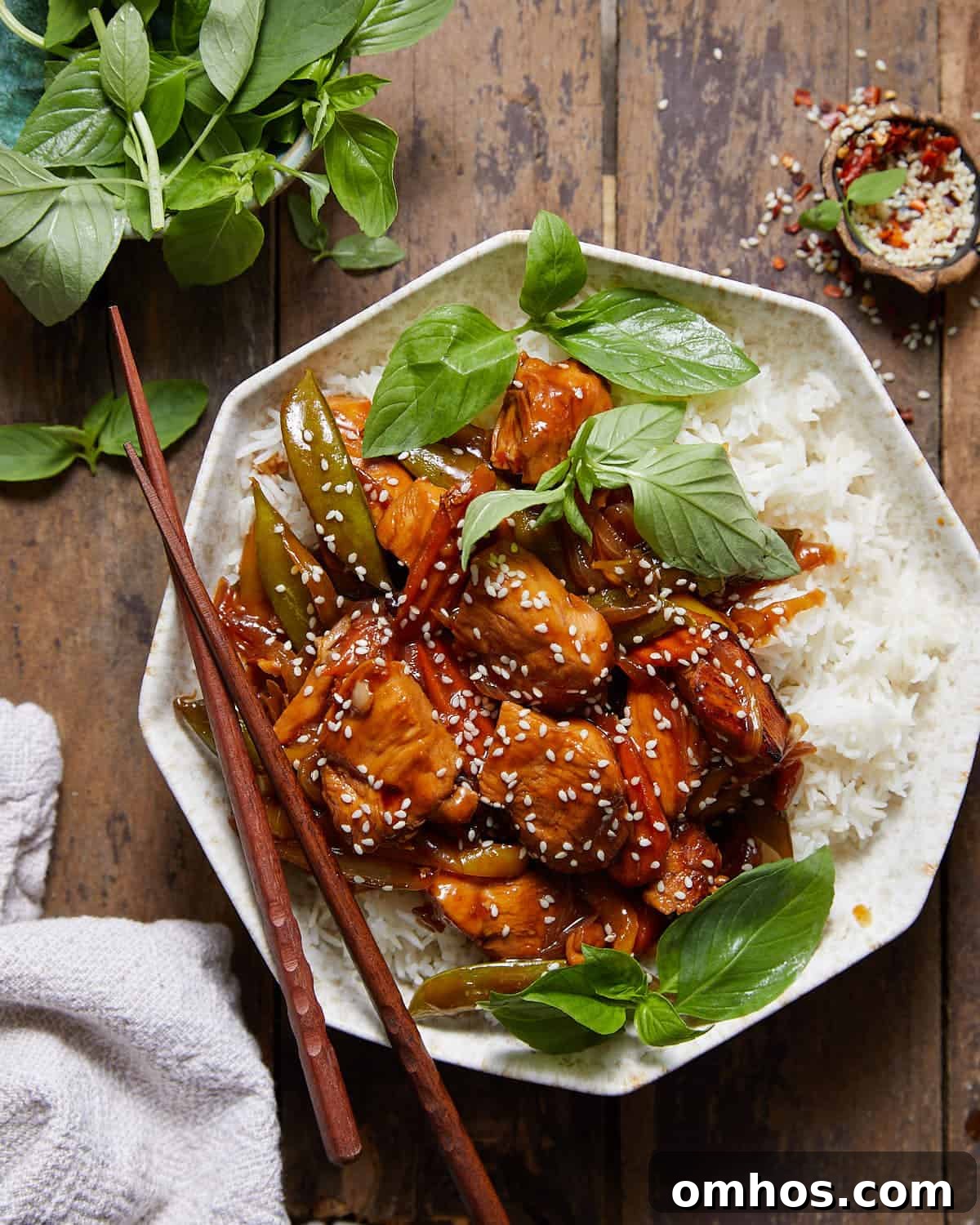 Stir fry marinated chicken and veggies over rice in a bowl.