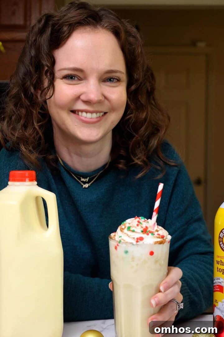 Eggnog Dirty Soda: Holiday Cocktail Recipe 3 Kelsey Smith with a glass of eggnog dirty soda in hand.
