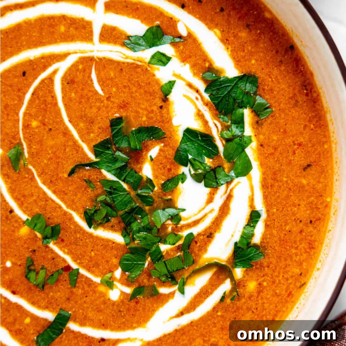 Roasted red pepper soup topped with sour cream and herbs.