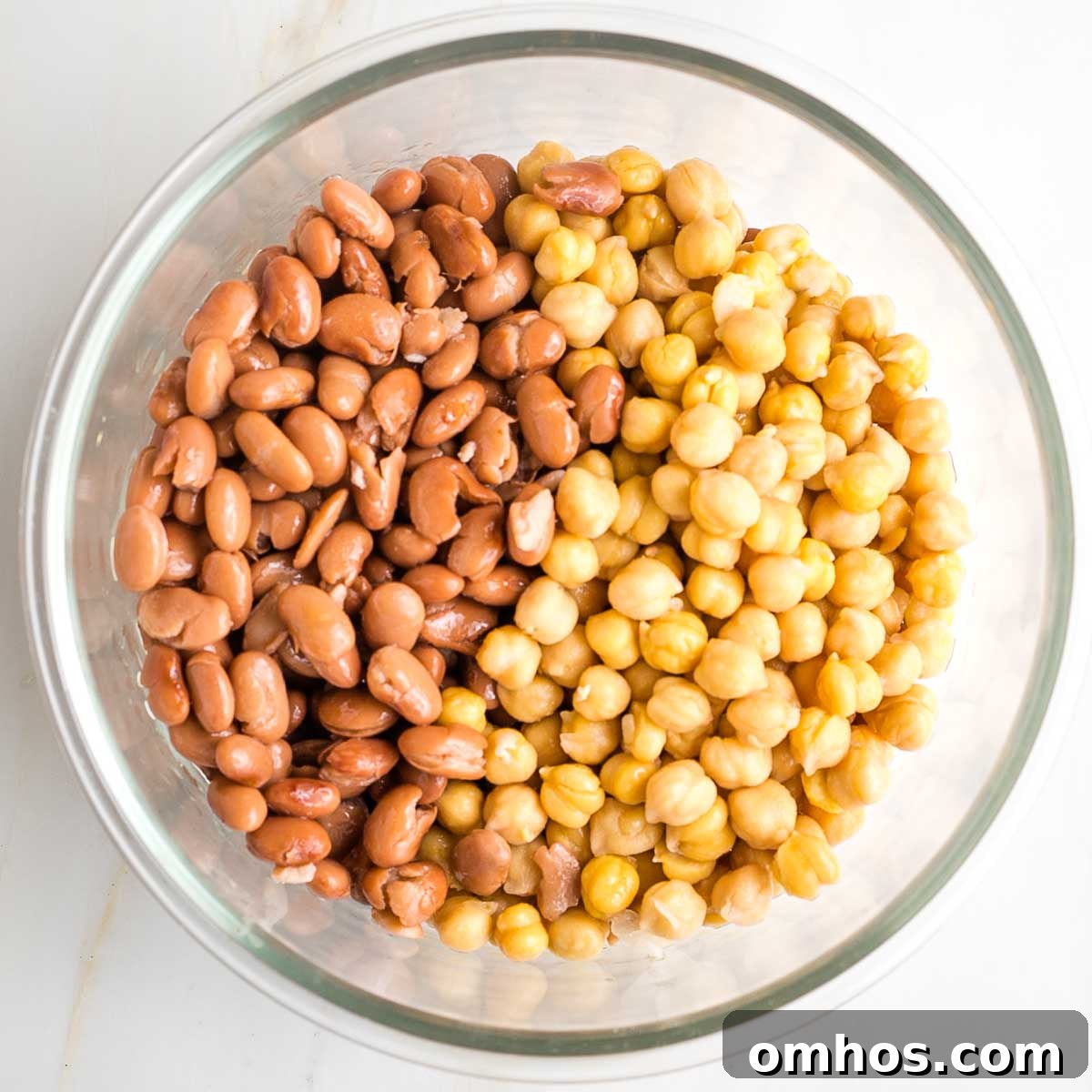 Pinto beans and chick peas in a glass mixing bowl.