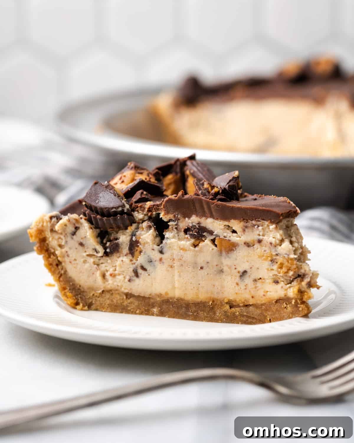 A slice of gluten free peanut butter pie topped with reese's peanut butter cups.
