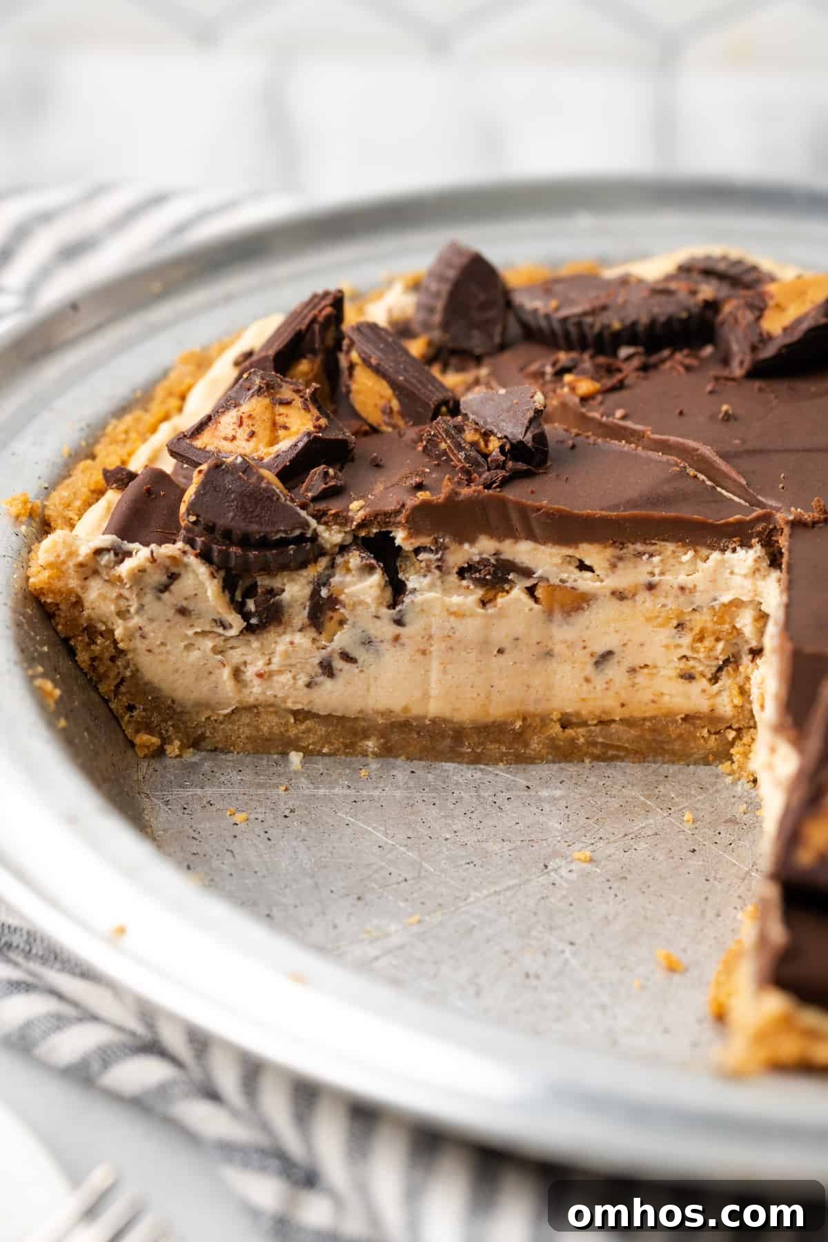 A sliced gluten free peanut butter pie in a metal pie dish. 