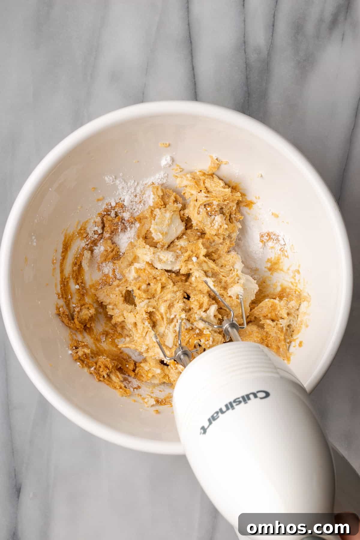 Peanut butter filling being mixed with a handheld mixer.