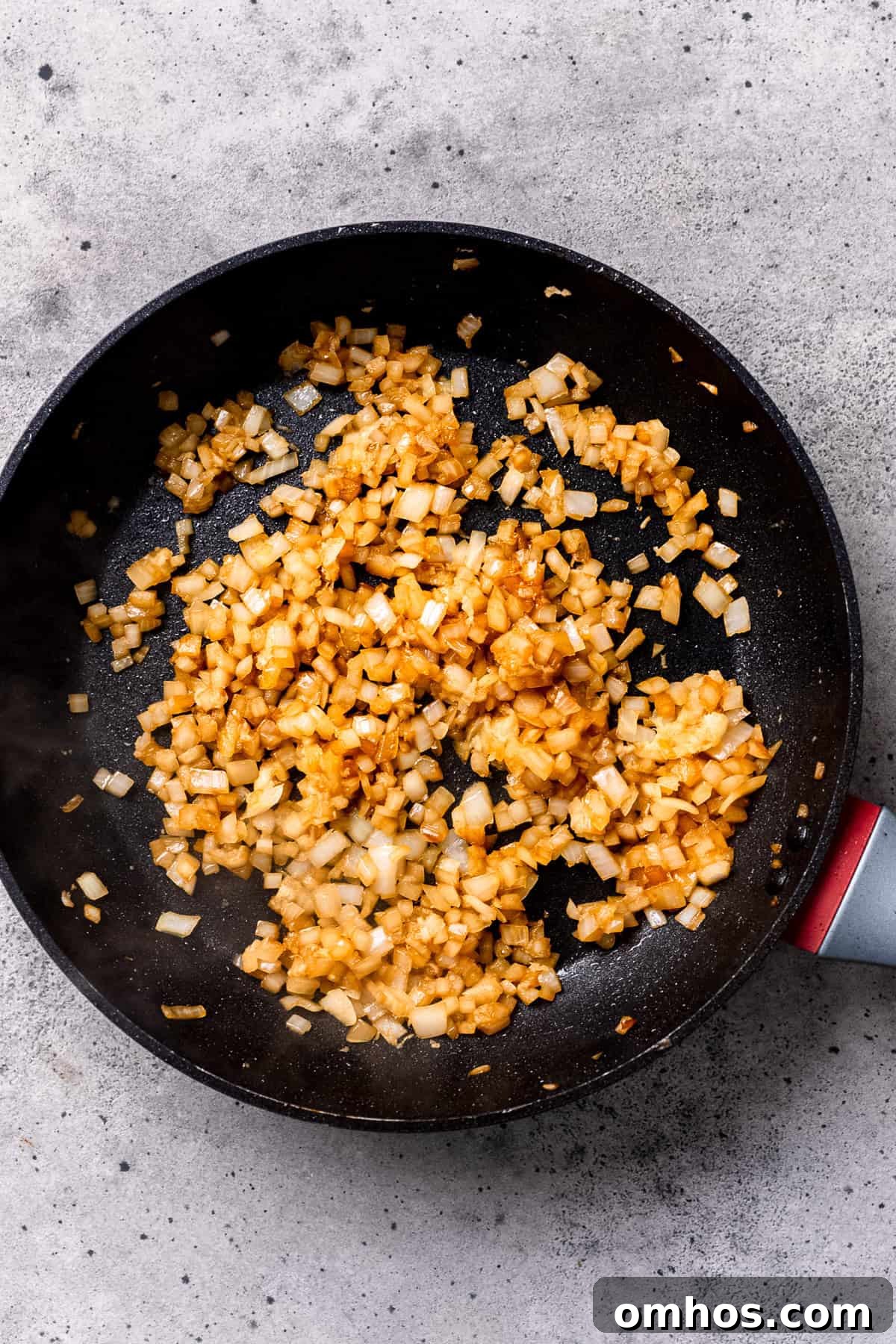 Sautéing onions in a pan for mushroom pork chops.
