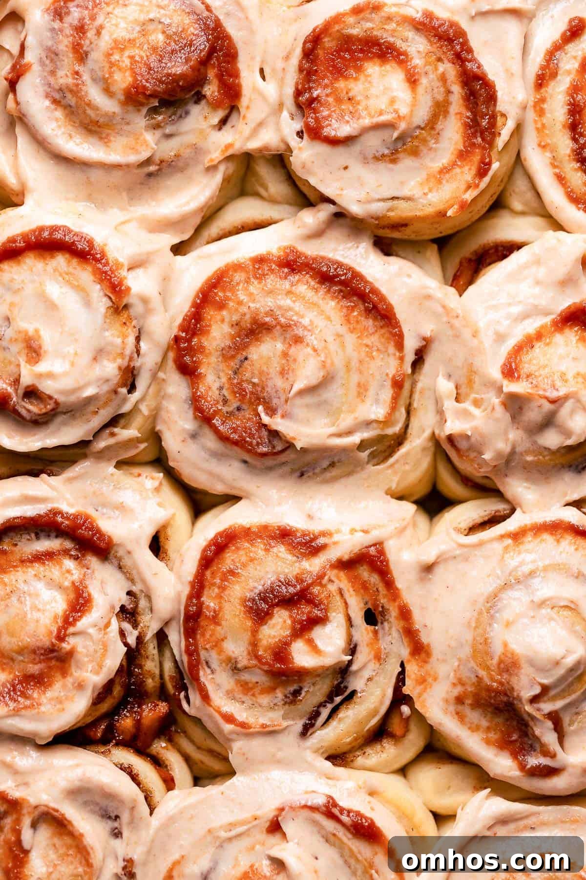 Cinnamon apple rolls with cream cheese frosting and a swirl of apple butter.