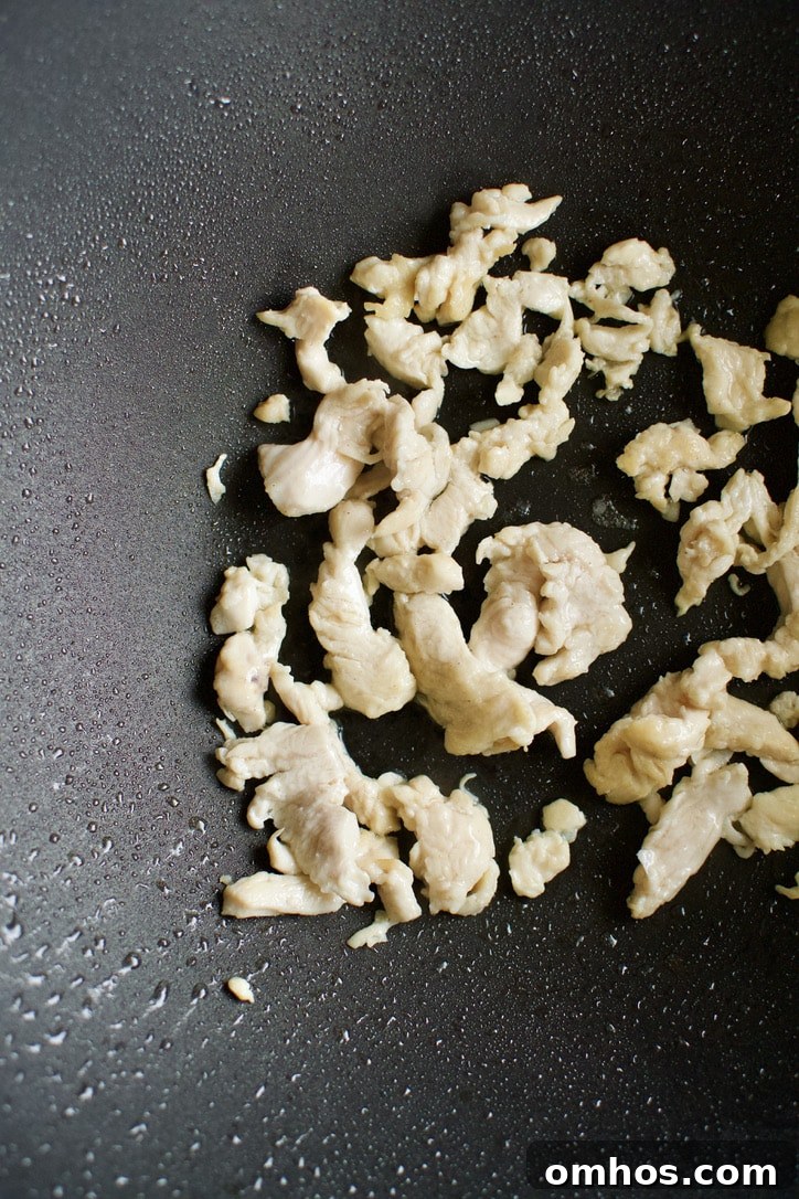 Chicken cooking in a hot wok.
