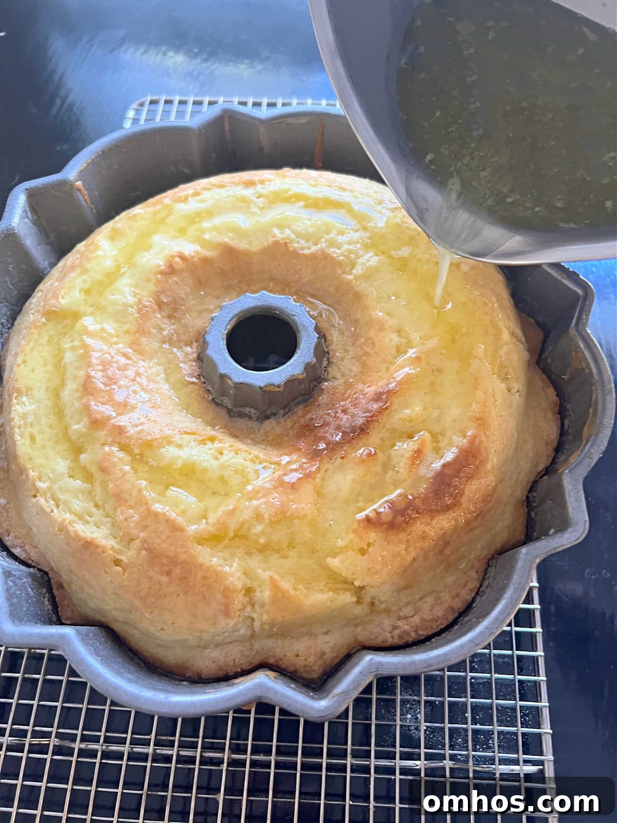 Moist Limoncello Bundt Cake with Lemon Glaze 4 Pouring the Limoncello Glaze over the freshly baked cake, still in the pan.